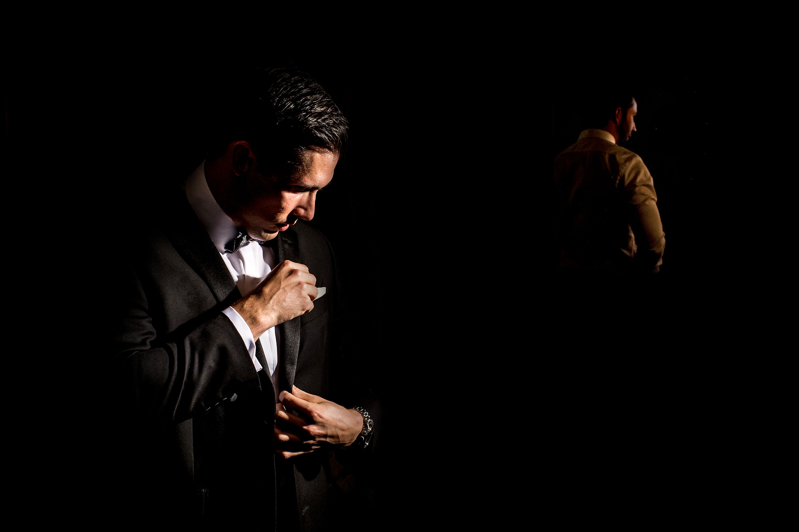 a groom adjusting his suit at Priddis Azuridge Wedding by sean leblanc