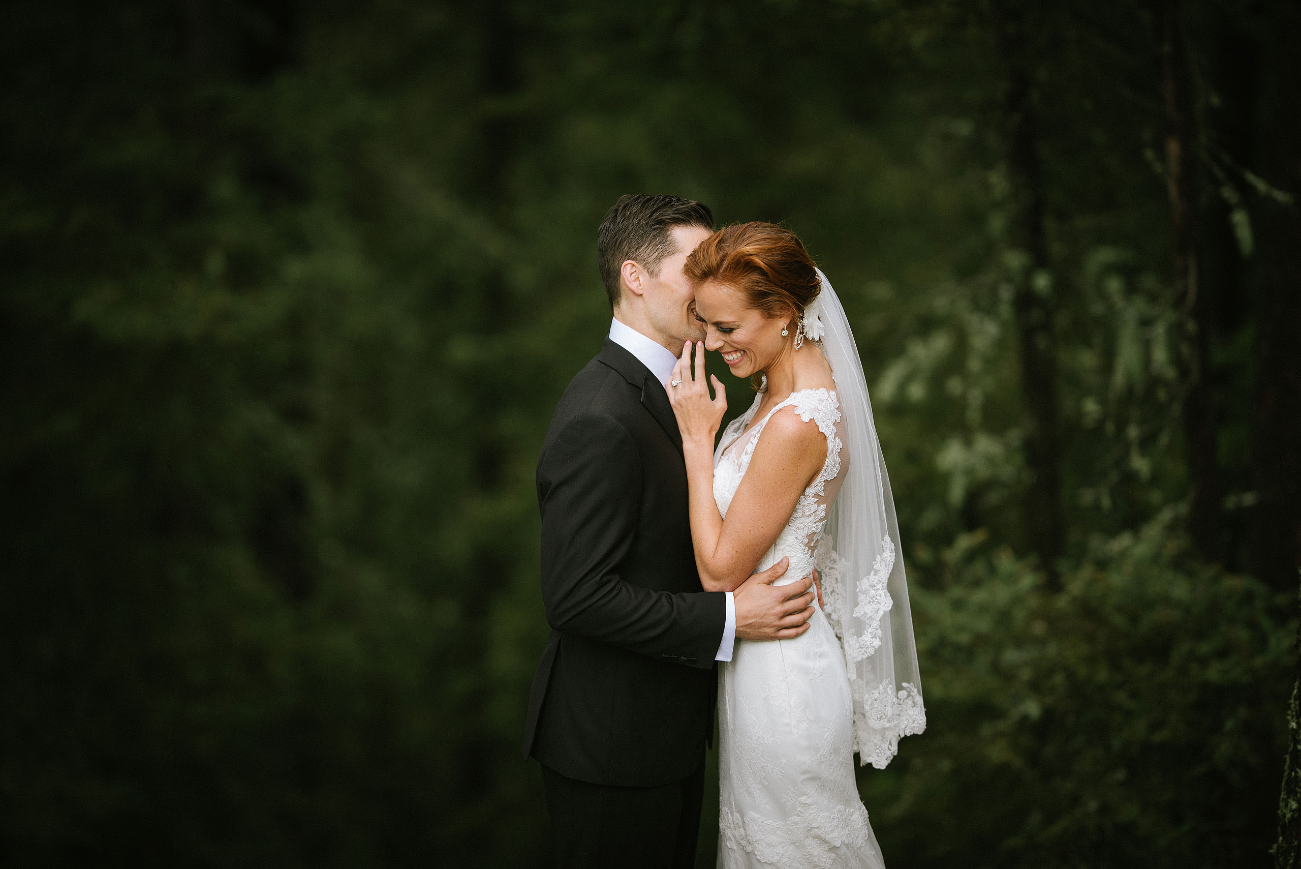 groom whispering into brides ear at Priddis Azuridge Wedding by sean leblanc