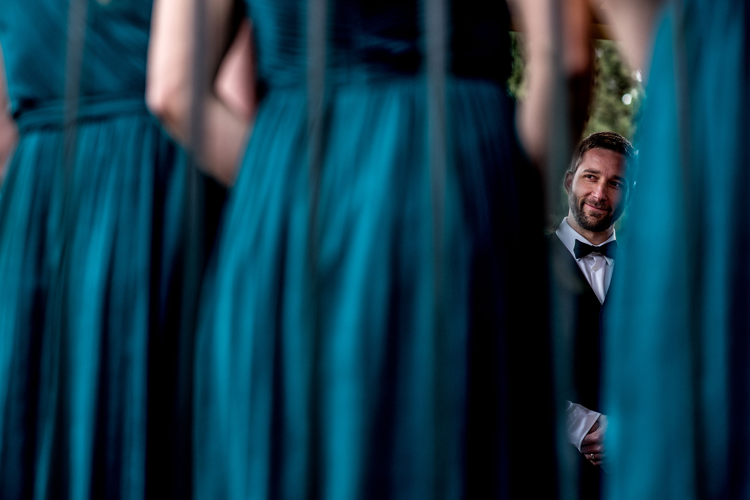 a groomsmen smiling at Priddis Azuridge Wedding by sean leblanc