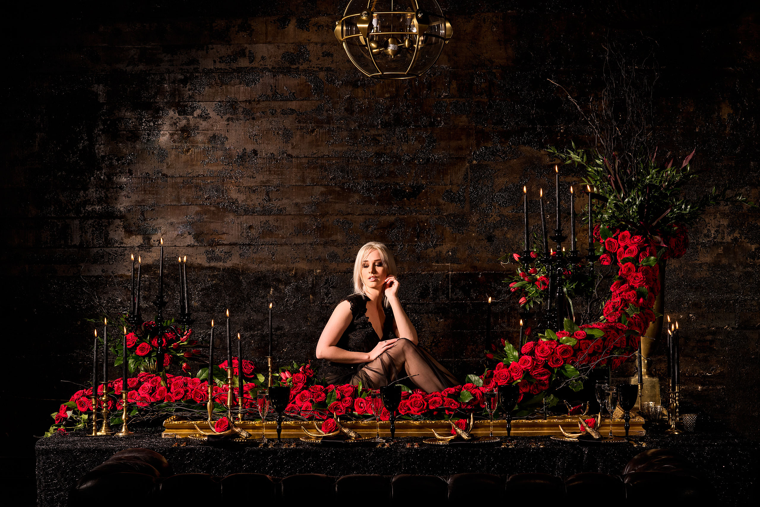 young female model posed on a table surrounded by roses by calgary confetti fashion photographer sean leblanc