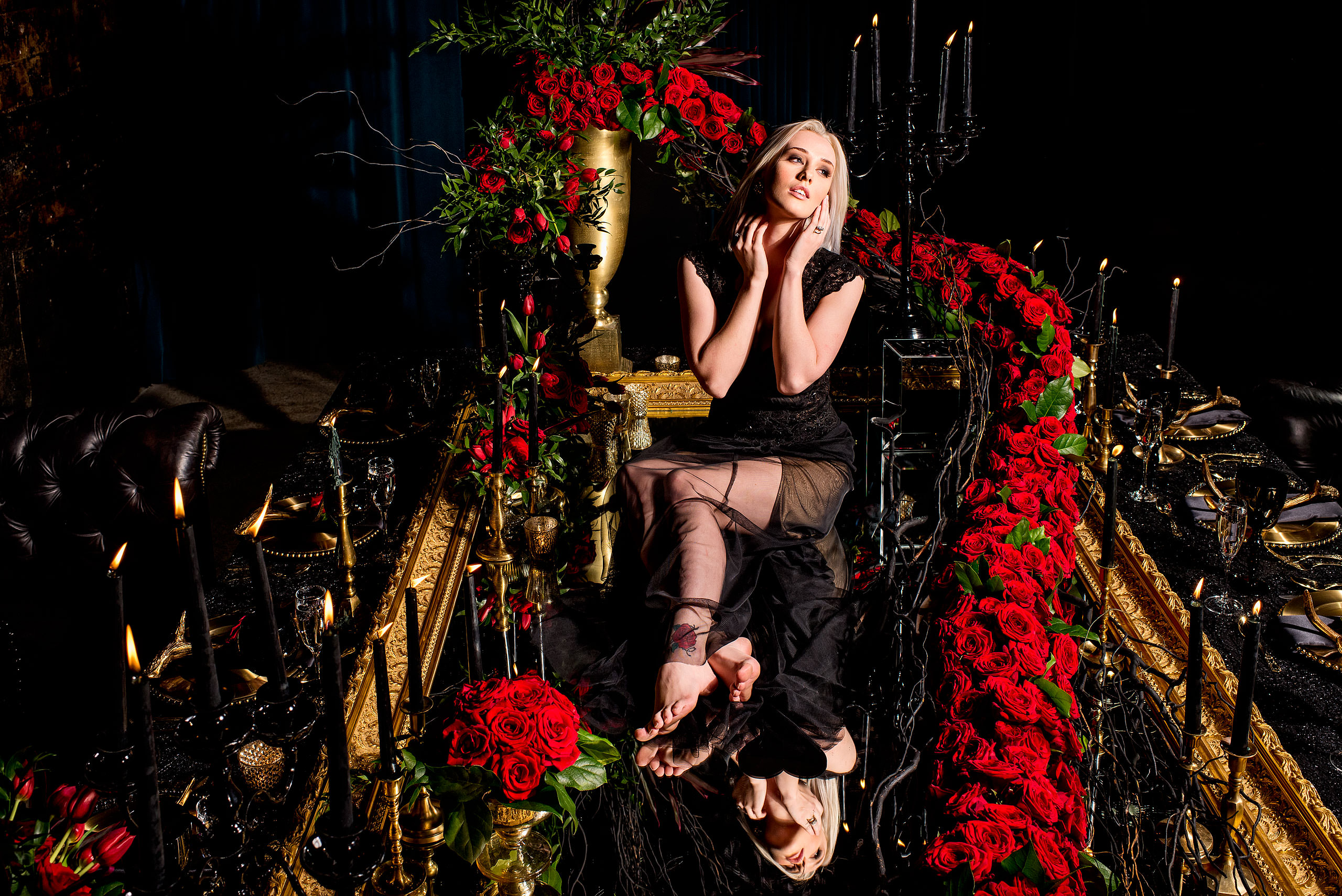 young female model sitting on a table surrounded by roses by calgary confetti fashion photographer sean leblanc