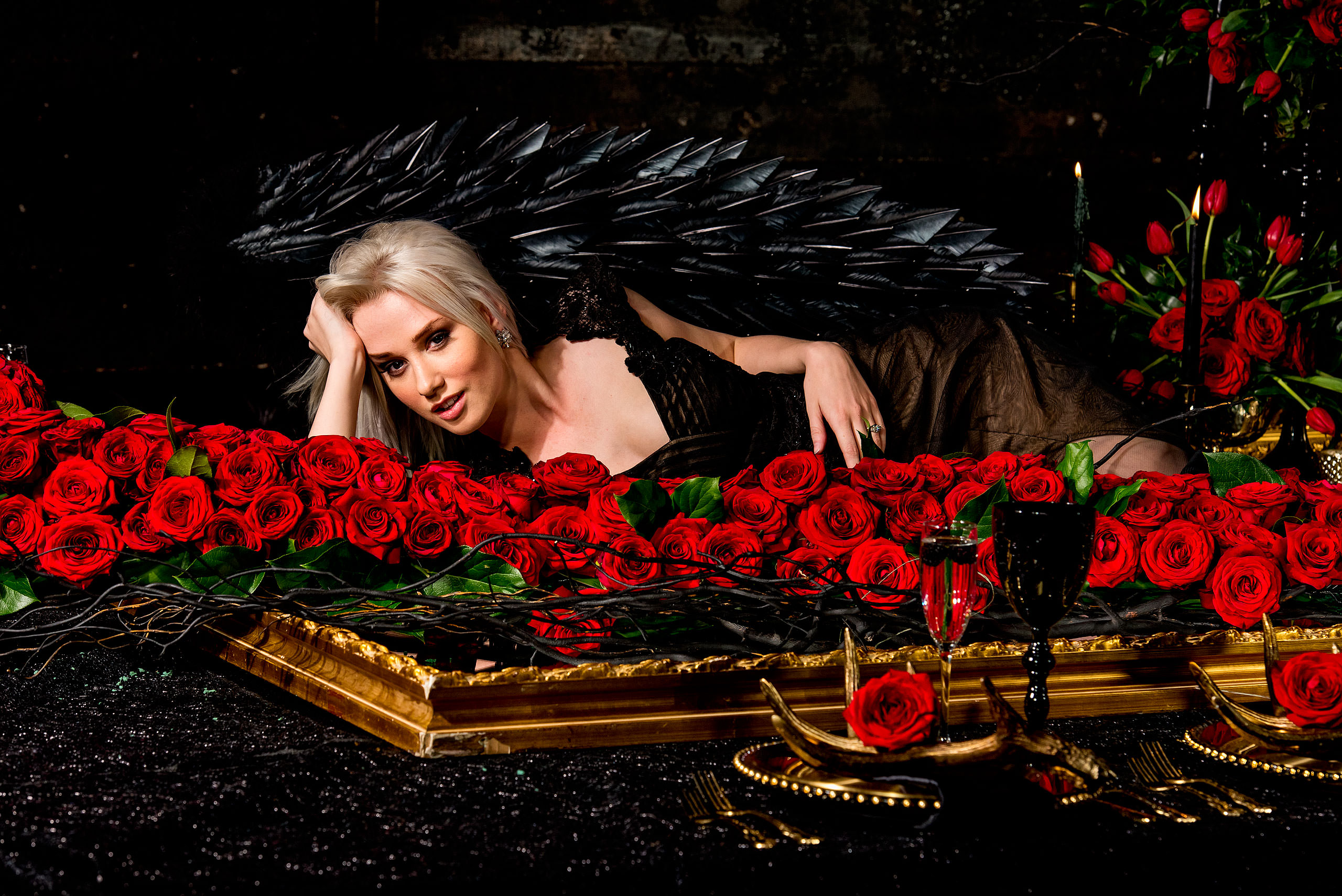 a model wearing wings laying behind roses by calgary confetti fashion photographer sean leblanc