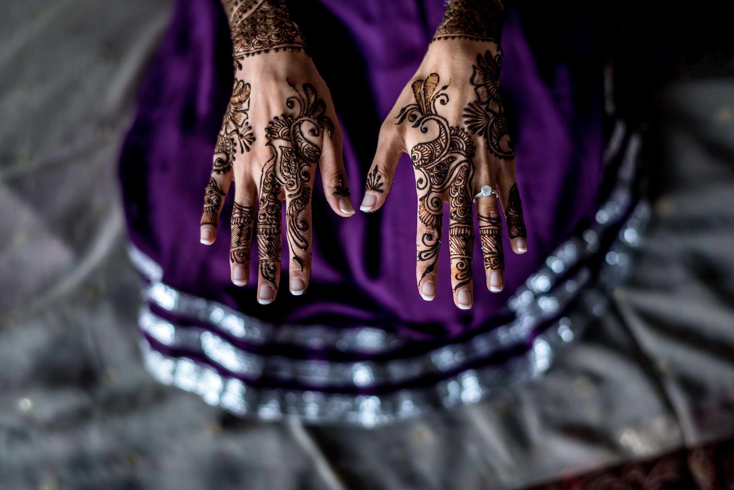 two hands above a purple dress with a wedding ring by Calgary Banff Wedding Photographer Sean LeBlanc