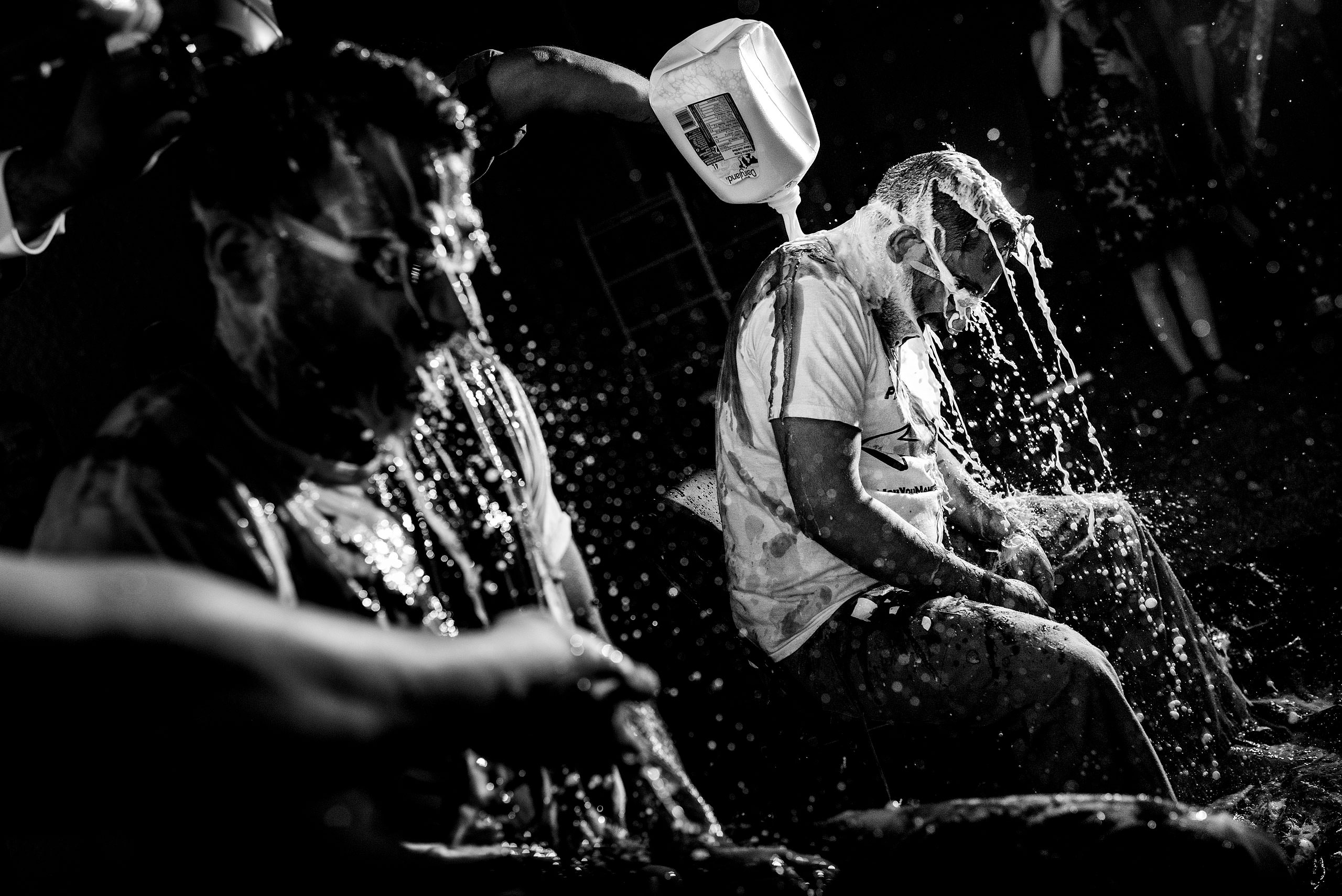 two Indian men getting milk poured on them by Calgary Banff Wedding Photographer Sean LeBlanc