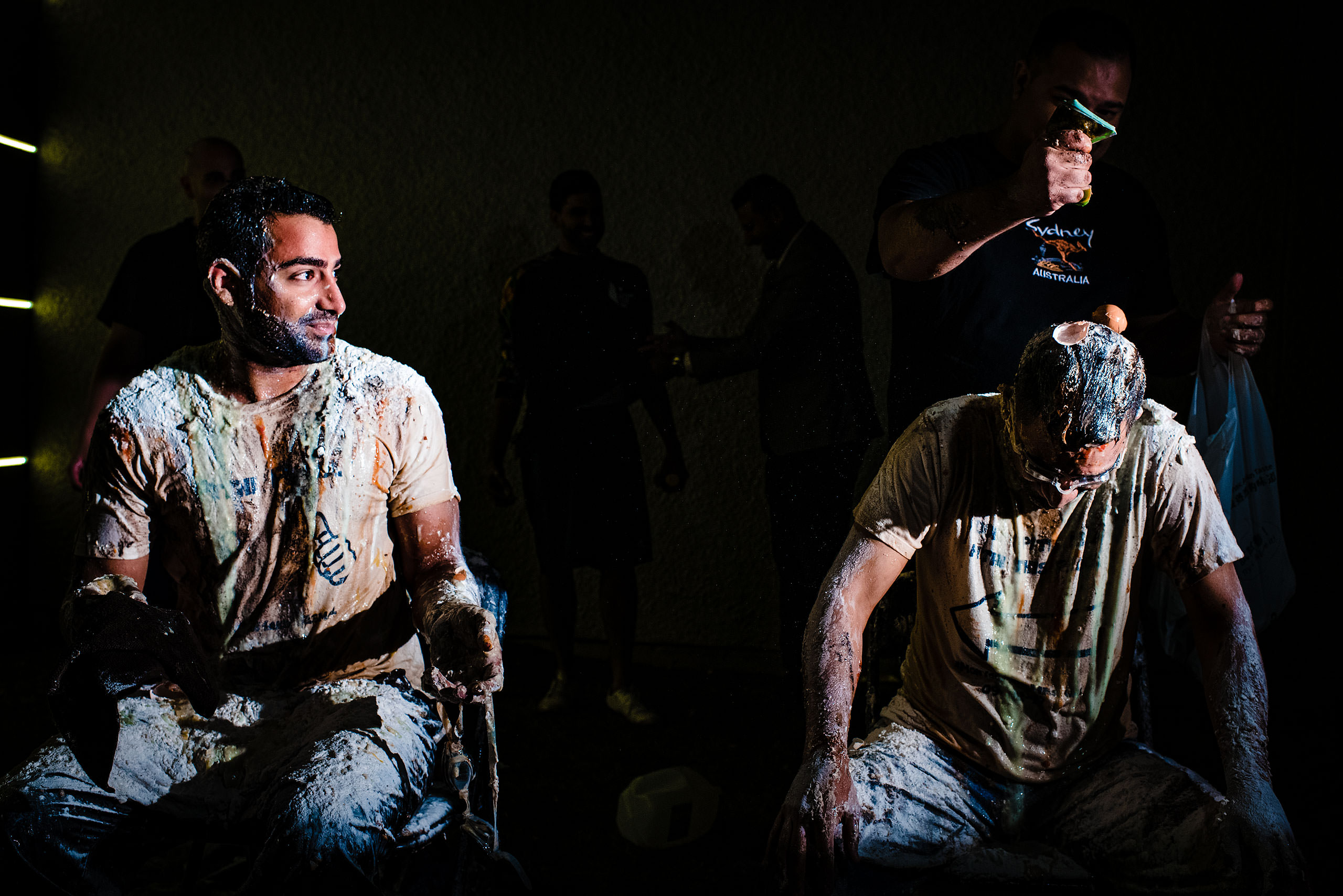 two Indian men getting milk poured on them by Calgary Banff Wedding Photographer Sean LeBlanc