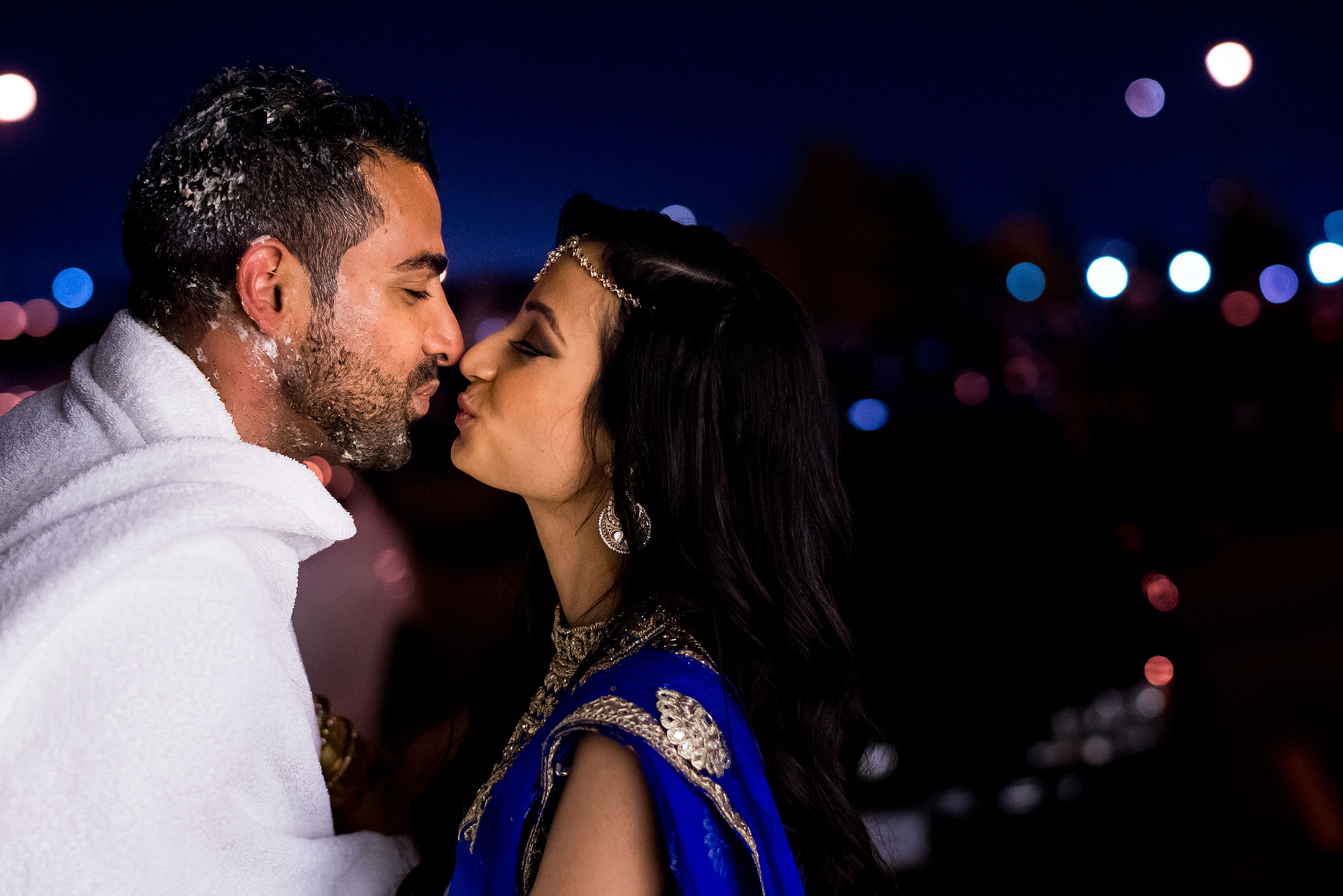 an indian bride and groom kissing in the night by Calgary Banff Wedding Photographer Sean LeBlanc