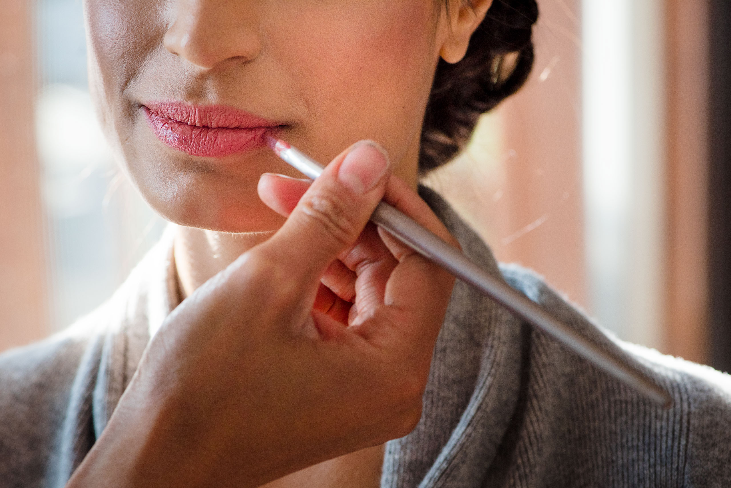 an indian bride having lipstick applied by Calgary Banff Wedding Photographer Sean LeBlanc