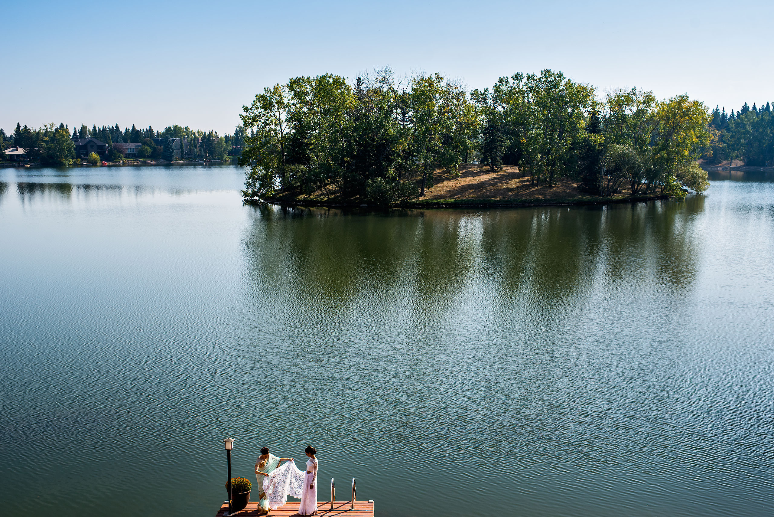 a mom and a daughter on a dock in front of a lake by Calgary Banff Wedding Photographer Sean LeBlanc