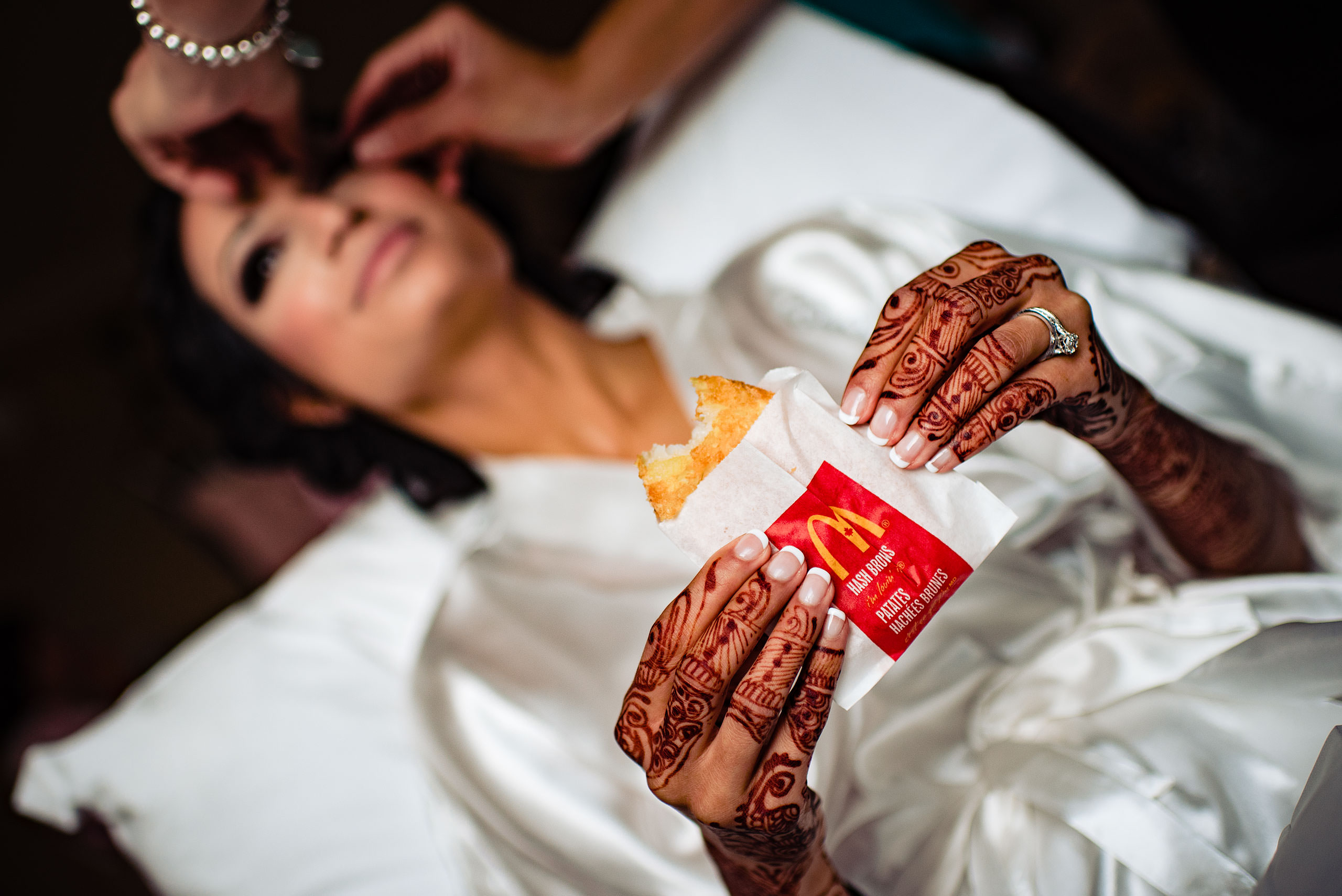 a bride eating a hashbrown from Mcdonalds by Calgary Banff Wedding Photographer Sean LeBlanc