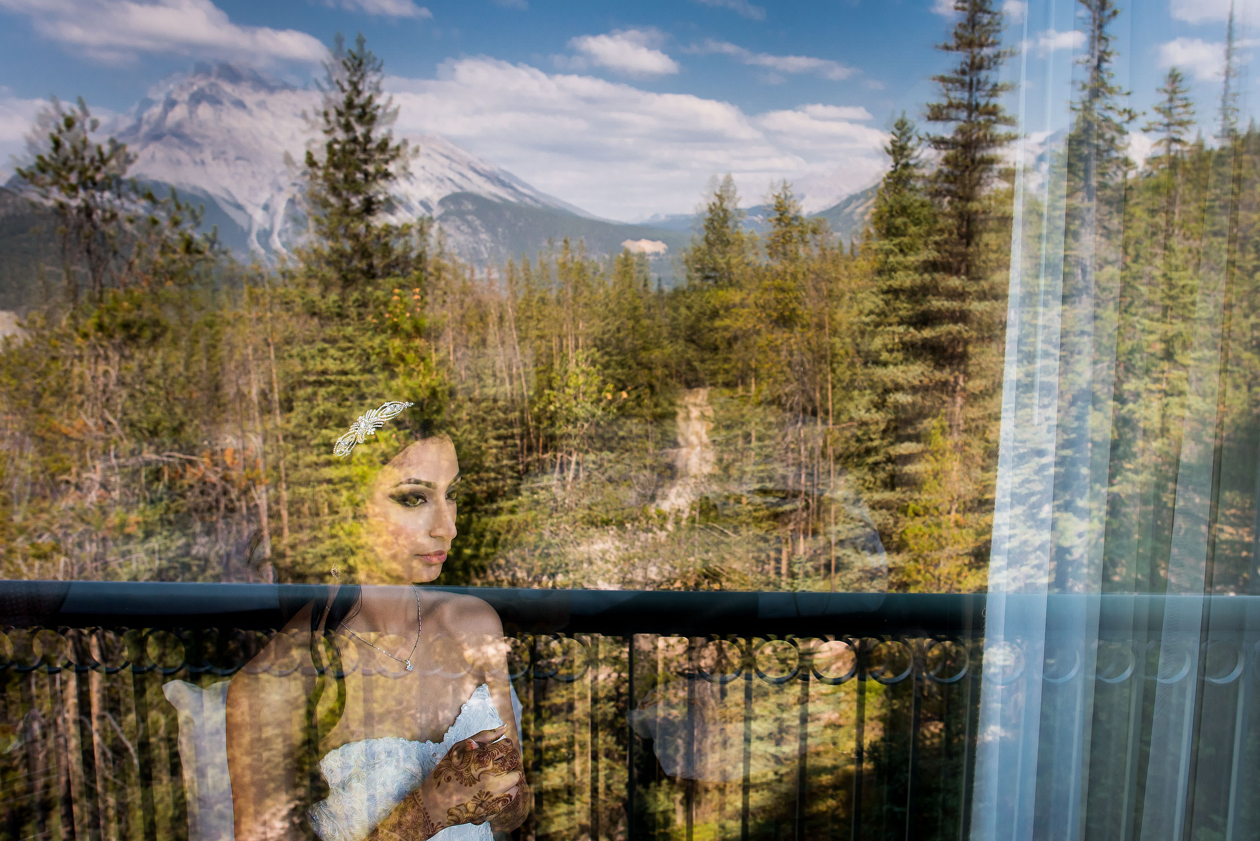 a bride looking out a window by Calgary Banff Wedding Photographer Sean LeBlanc