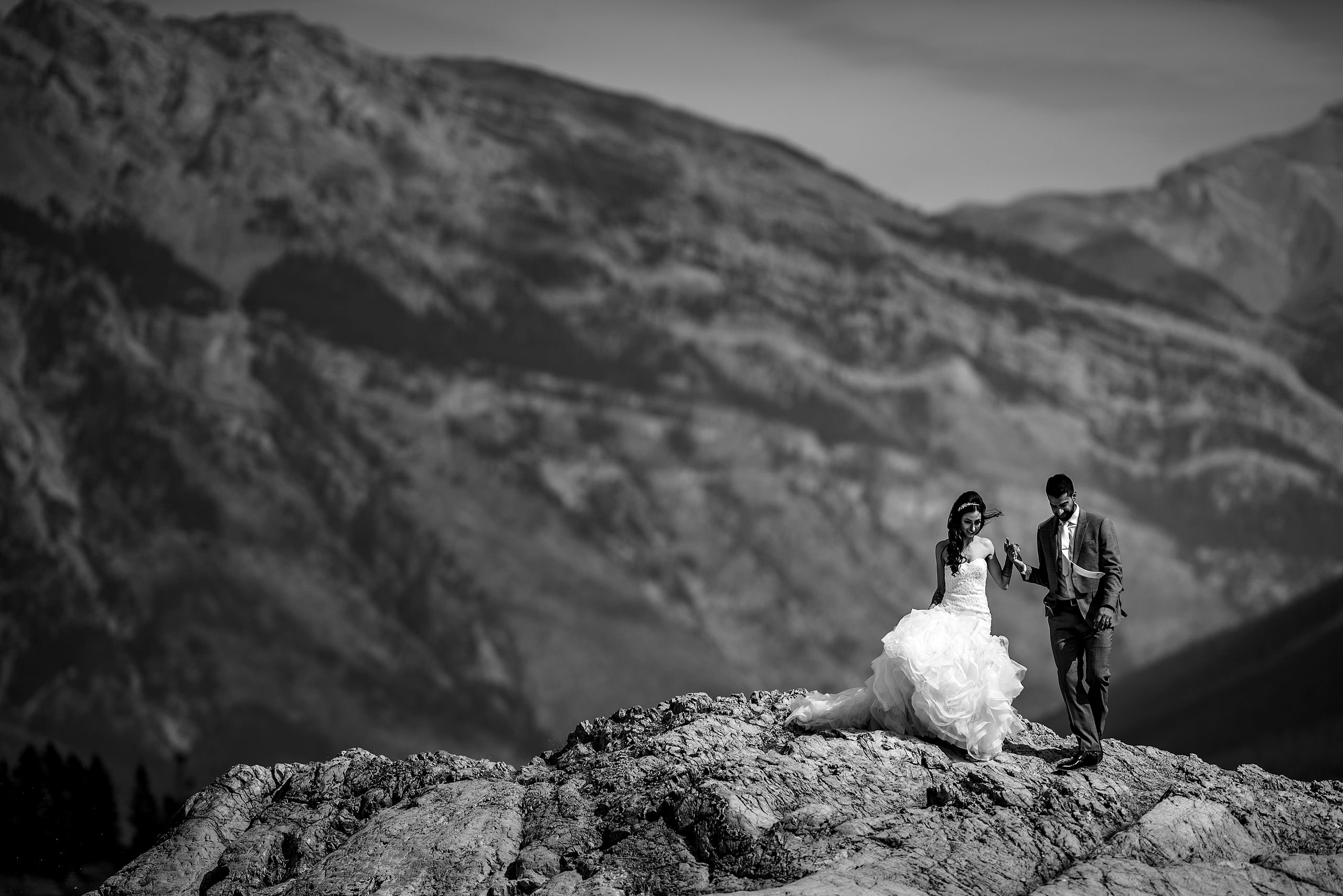 a bride and groom walking down from a rock by Calgary Banff Wedding Photographer Sean LeBlanc