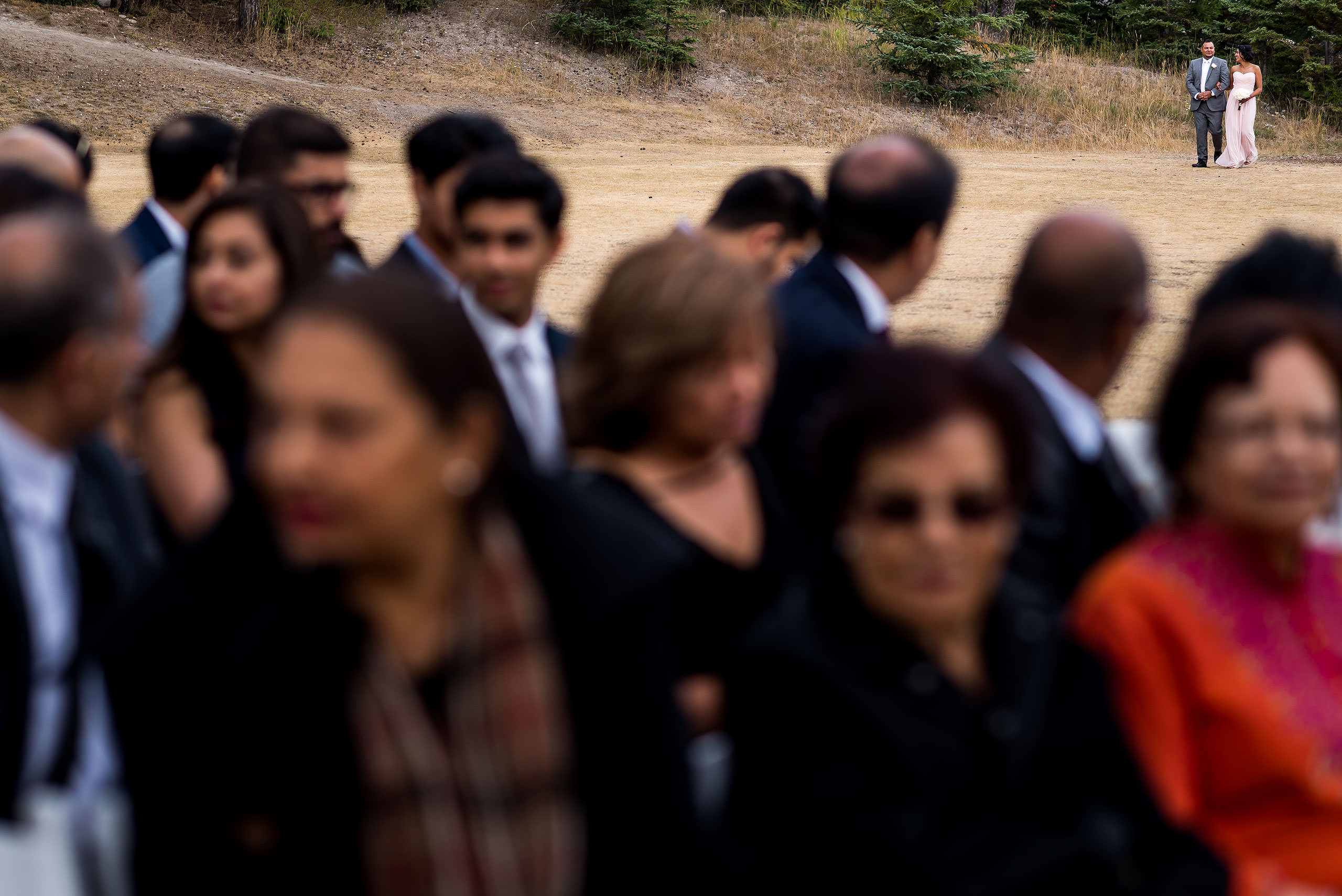 a wedding couple walking in a field by Calgary Banff Wedding Photographer Sean LeBlanc