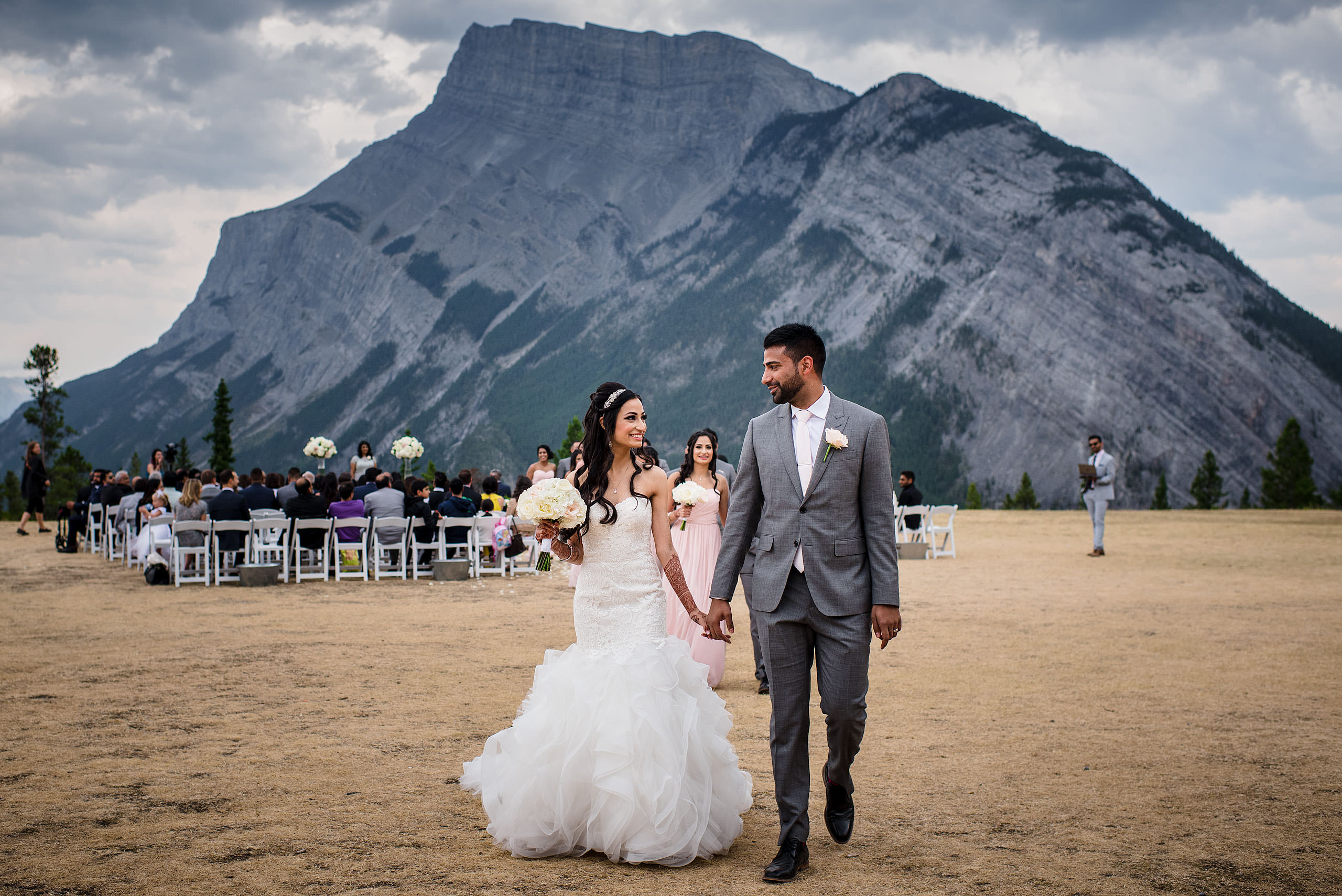 a bride and groom walking from their wedding ceremony by Calgary Banff Wedding Photographer Sean LeBlanc