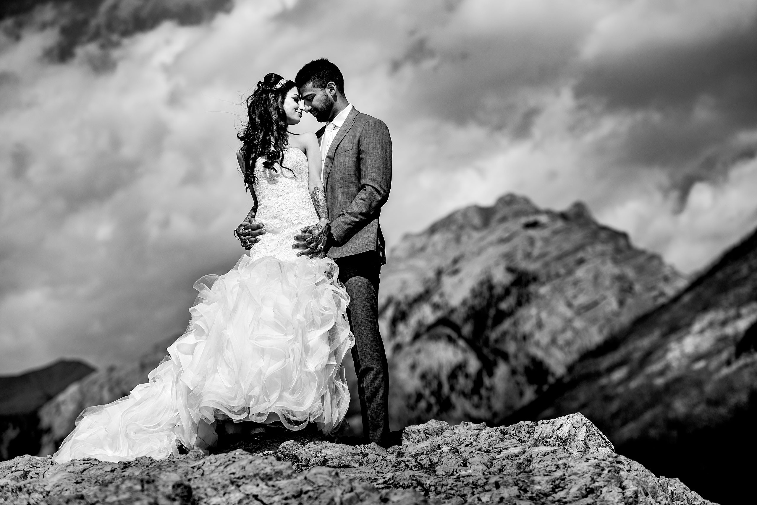 a bride and groom embracing on a mountain top by Calgary Banff Wedding Photographer Sean LeBlanc