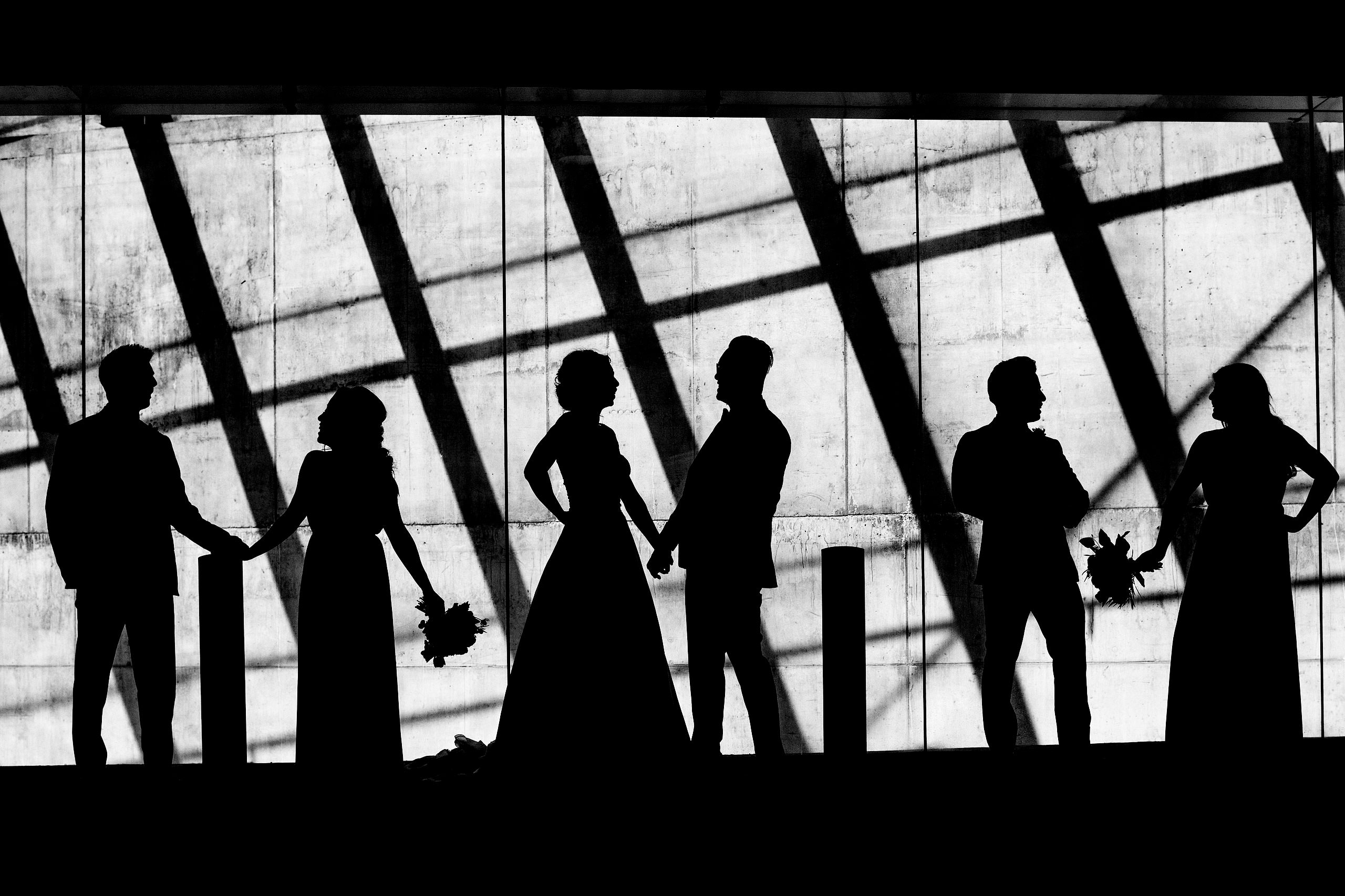 a bride party standing infant of a wall as a silhouette by top calgary wedding photographer sean leblanc