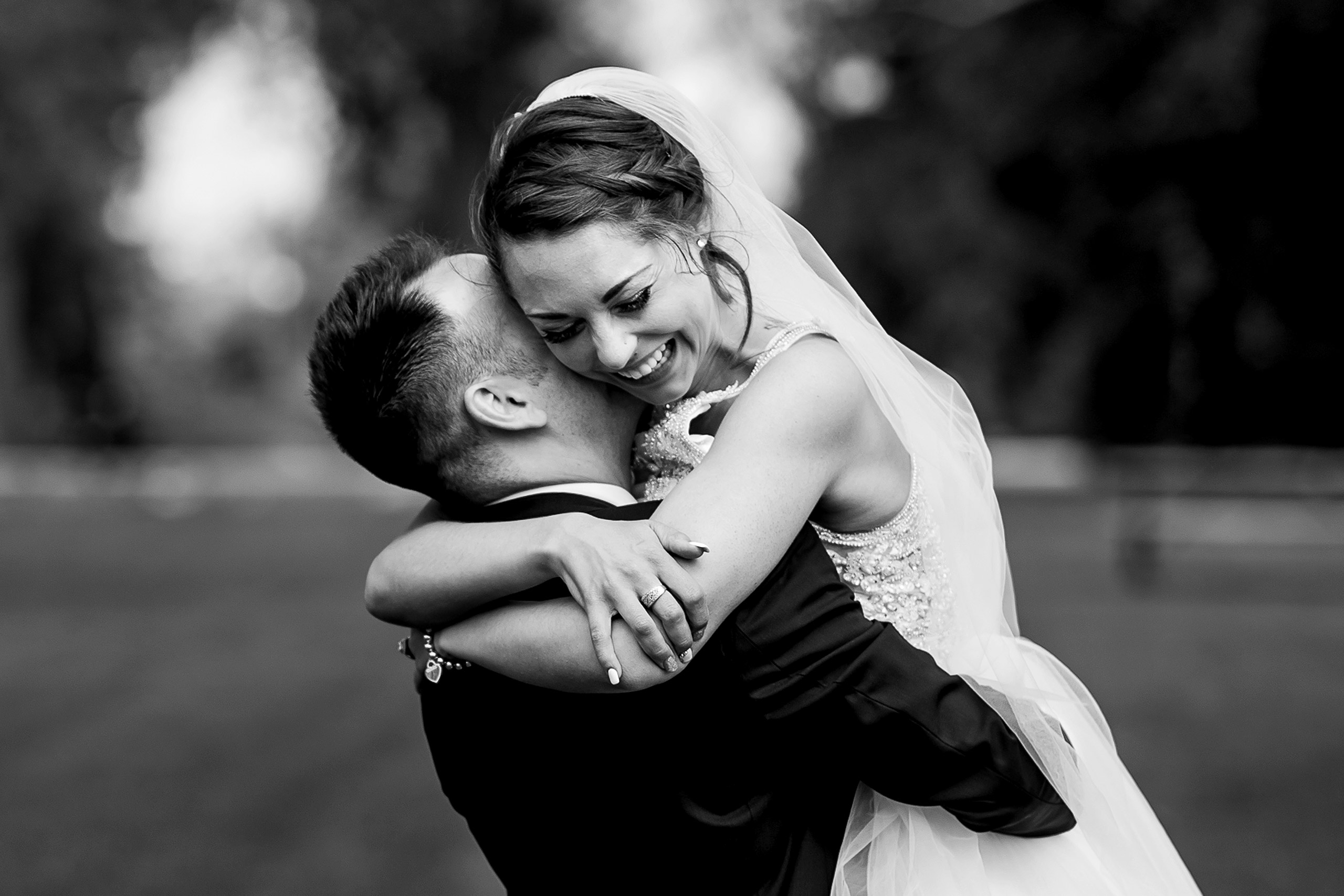 bride and groom embracing in the park by calgary wedding photographer sean leblanc