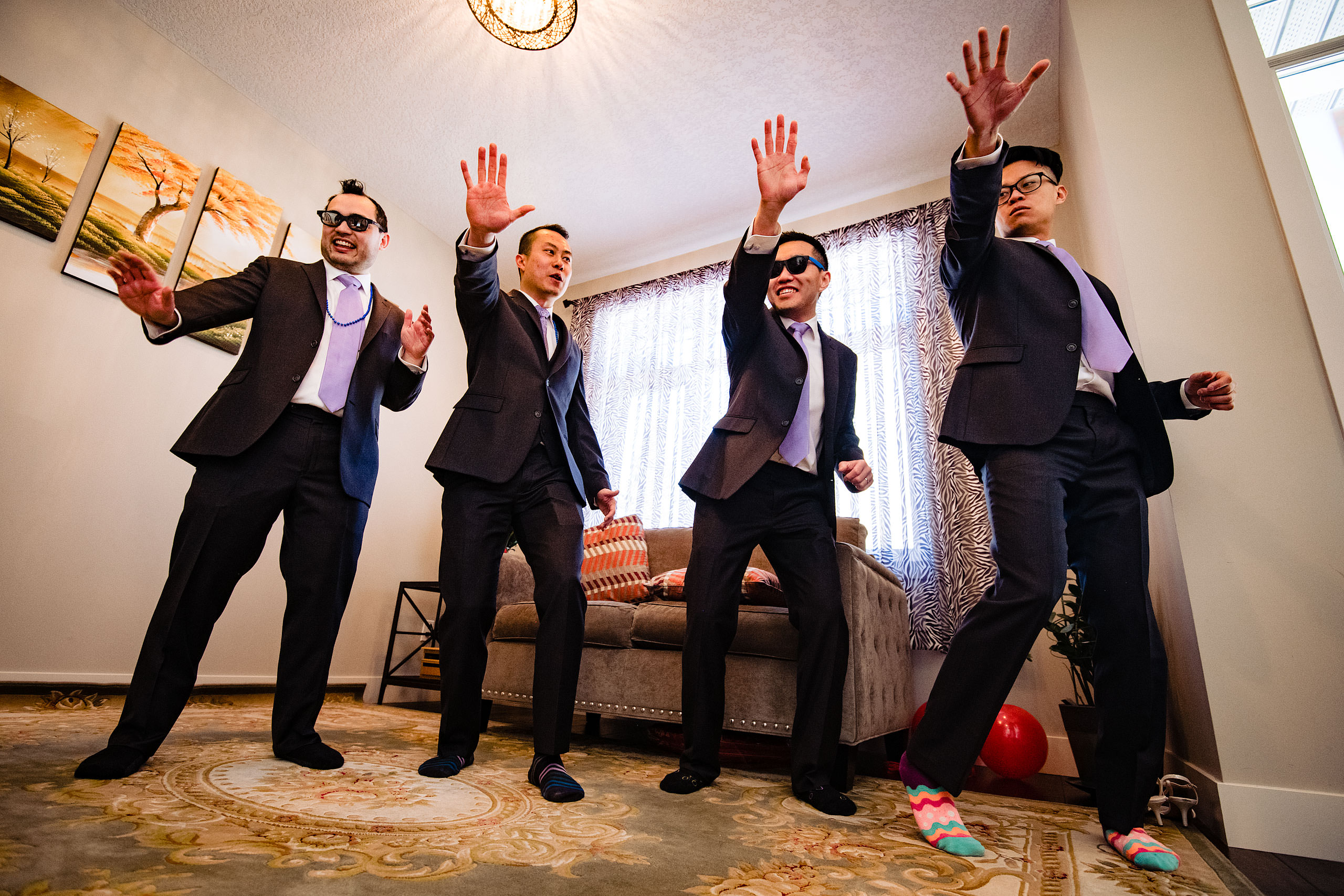 four groomsmen dancing to bruno mars at a calgary lake house wedding by calgary wedding photographer sean leblanc photography