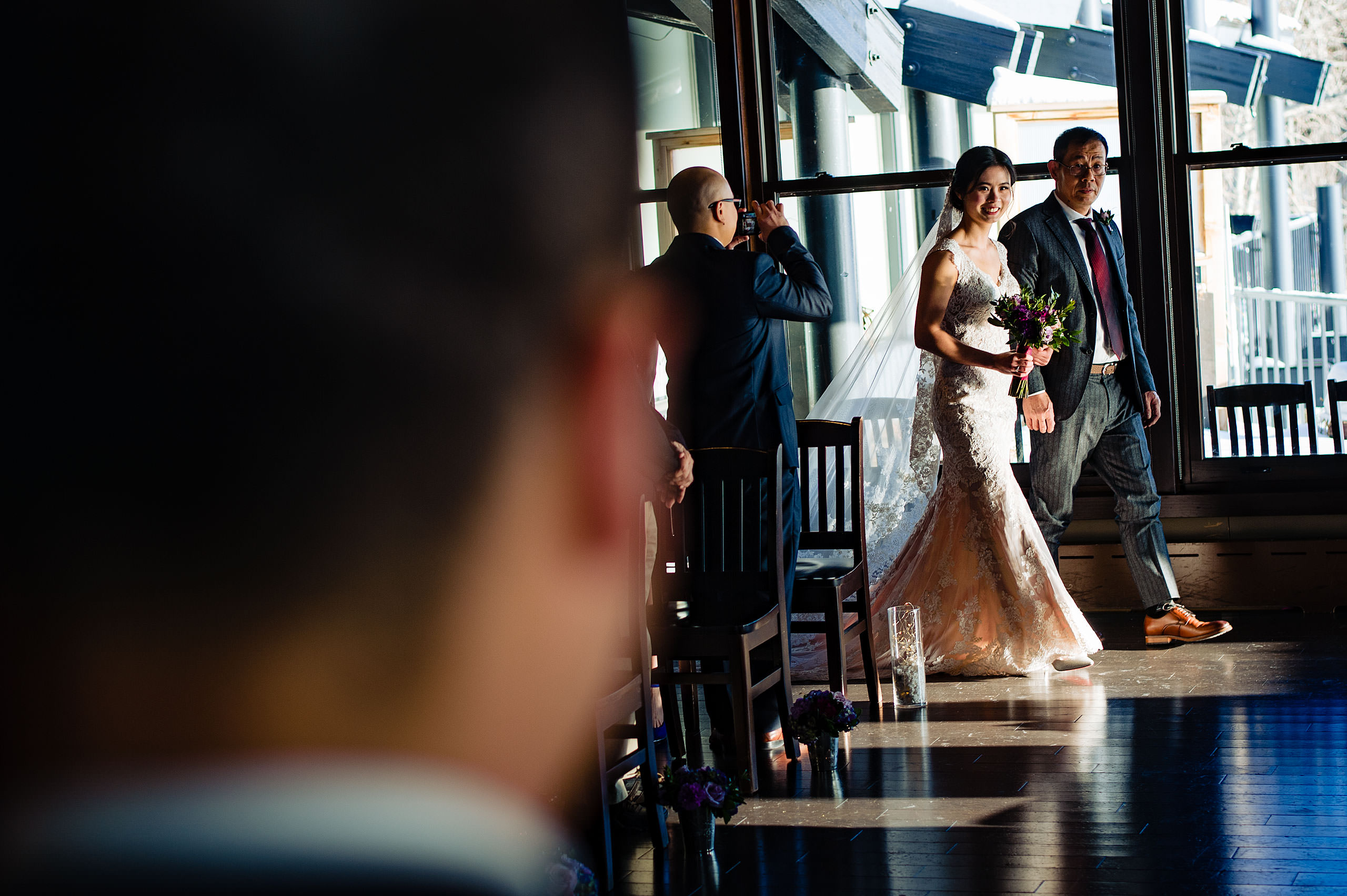 a bride being walked down the aisle by her dad for their calgary lake house wedding by calgary wedding photographer sean leblanc photography