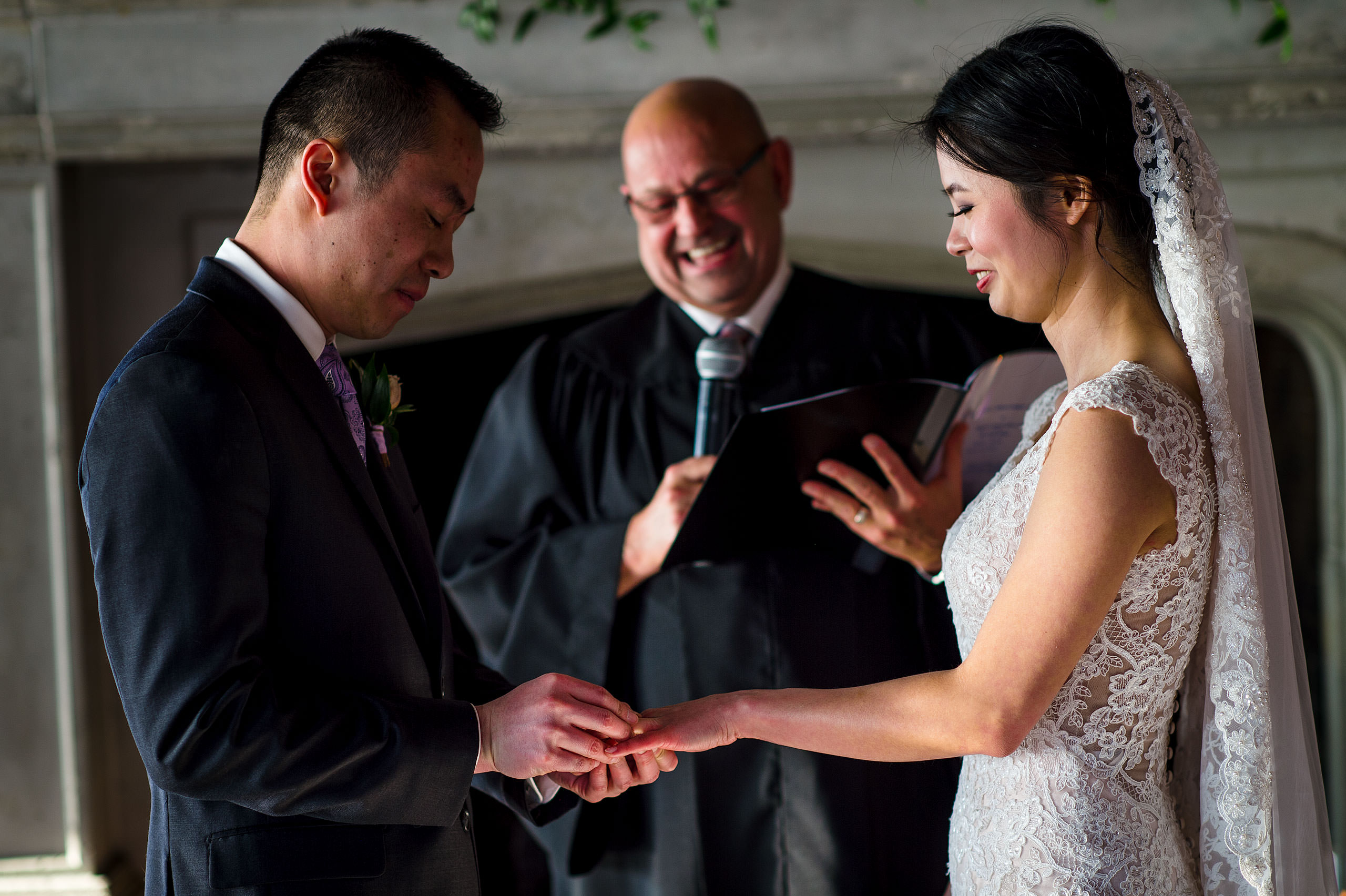 a bride and groom exchanging rings for their calgary lake house wedding by calgary wedding photographer sean leblanc photography