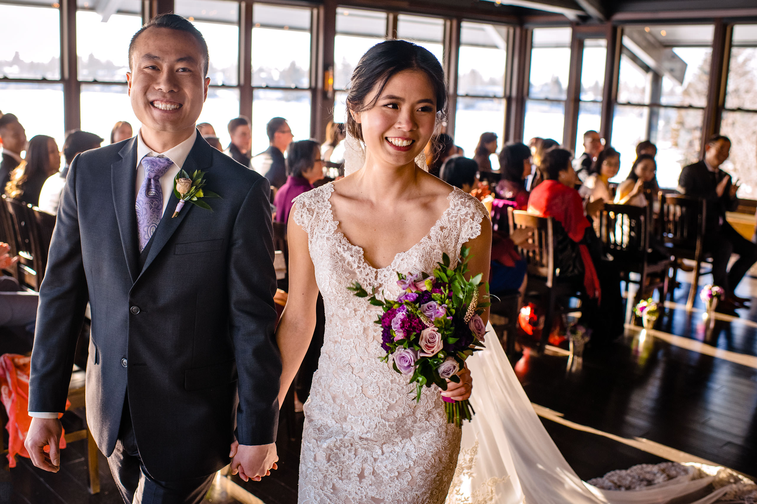 a bride and groom walking down the aisle as a married couple at their calgary lake house wedding by calgary wedding photographer sean leblanc photography