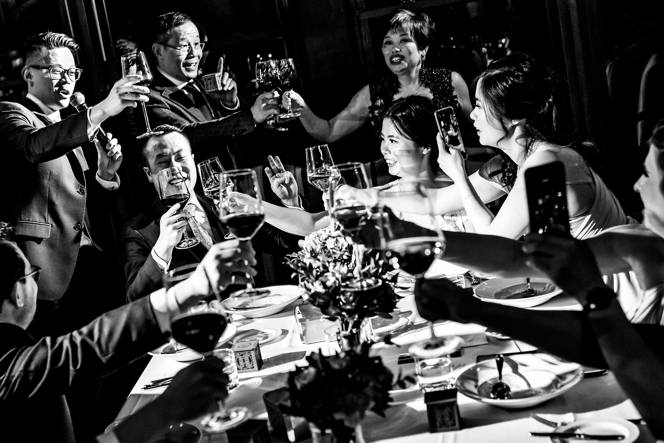 a group of people clinking glasses at a calgary lake house wedding by calgary wedding photographer sean leblanc photography