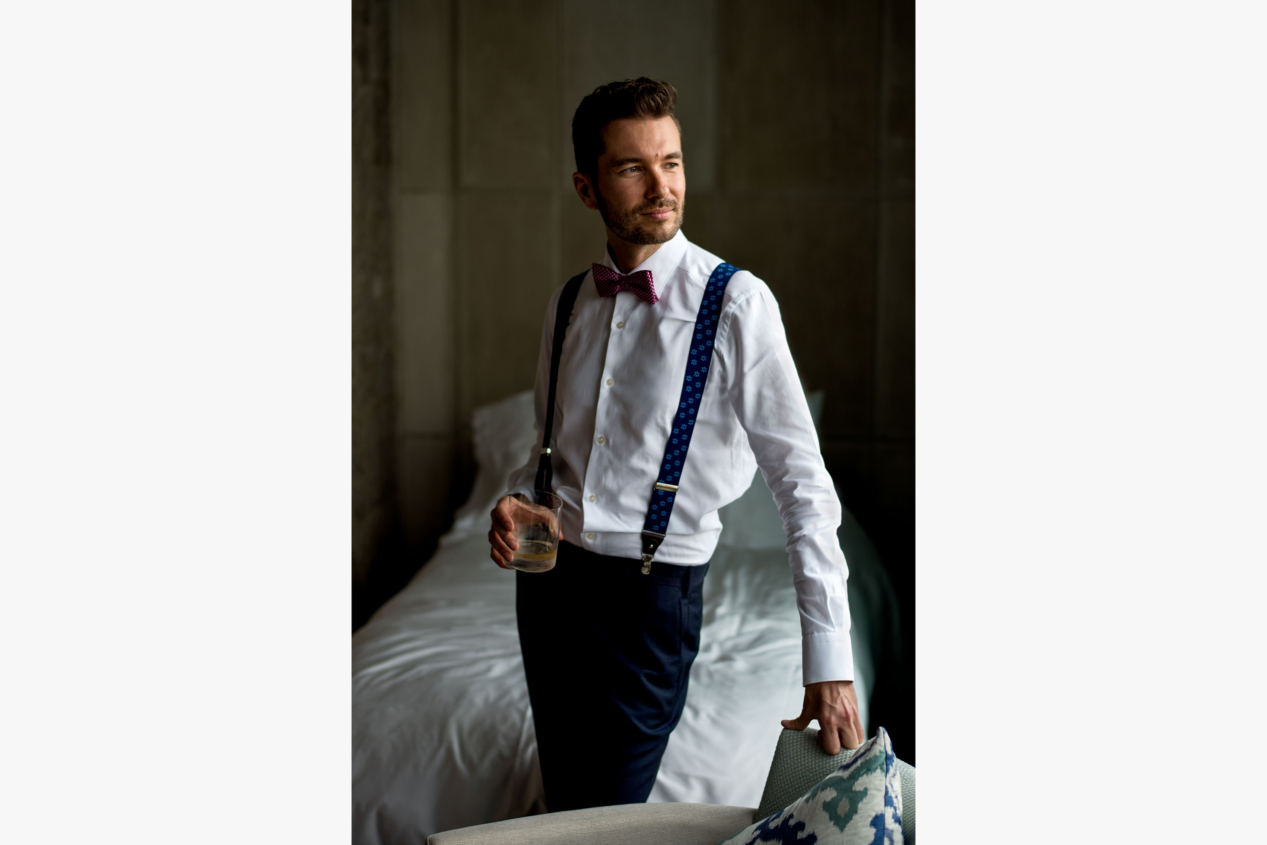 groom leaning against a chair holding a drink at castillo hotel son vida destination wedding by sean leblanc